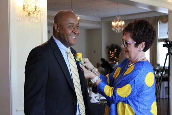 Mrs. Reneé Hodges pins a boutonniere on 2024 honoree Sandy Hines.