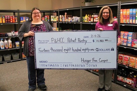 P&HCC Foundation Executive Director Tiffani Underwood (R) presents a grant check to Pantry Coordinator Heather Luther (L) on behalf of Hunger-Free Campus.